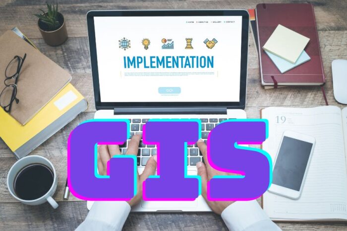 Hands typing on a silver laptop with the words GIS overlaid.
