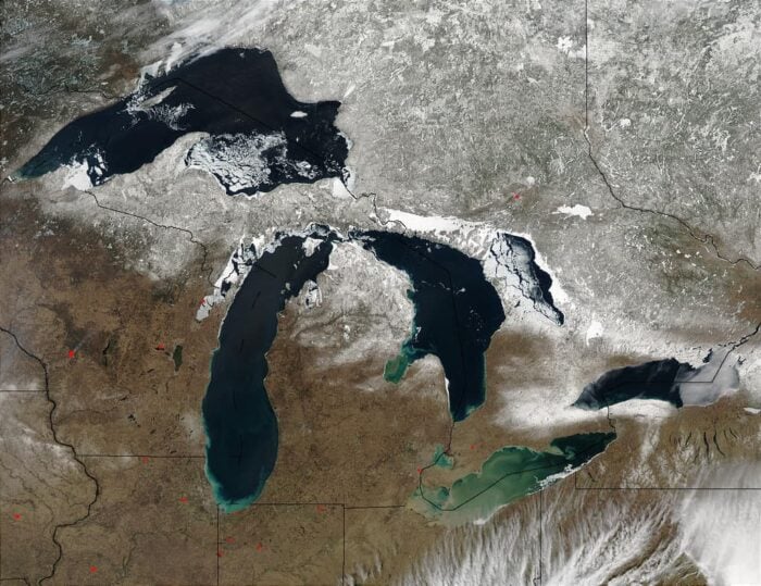 Satellite image of the Great Lakes with brown ground and a scattering of snow to the north.