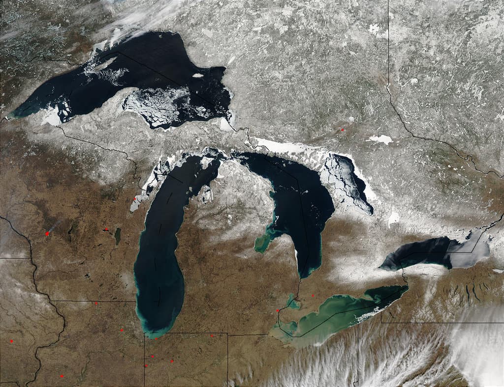 Satellite image of the Great Lakes with brown ground and a scattering of snow to the north.