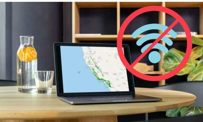 A view of a desk with a laptop open with a map on it and the symbol for "No WIFI" overlaid.