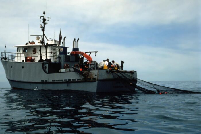 USGS fishery biologists direct a trawl net as it is released into Lake Huron from a research fishing boat.