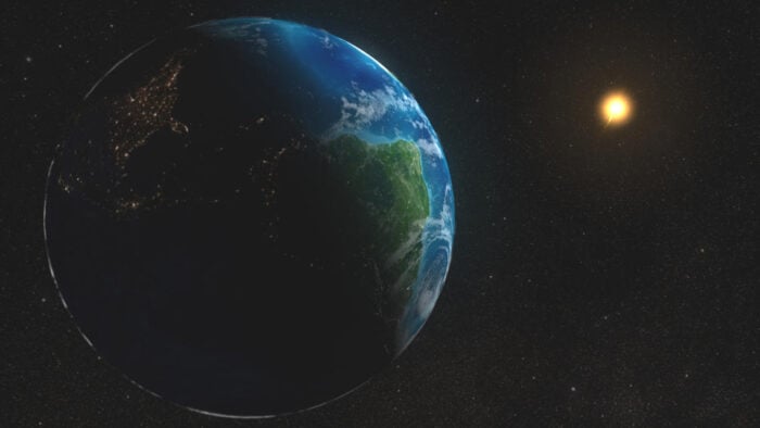 An artistic view of the Earth and the Sun against a dark background.