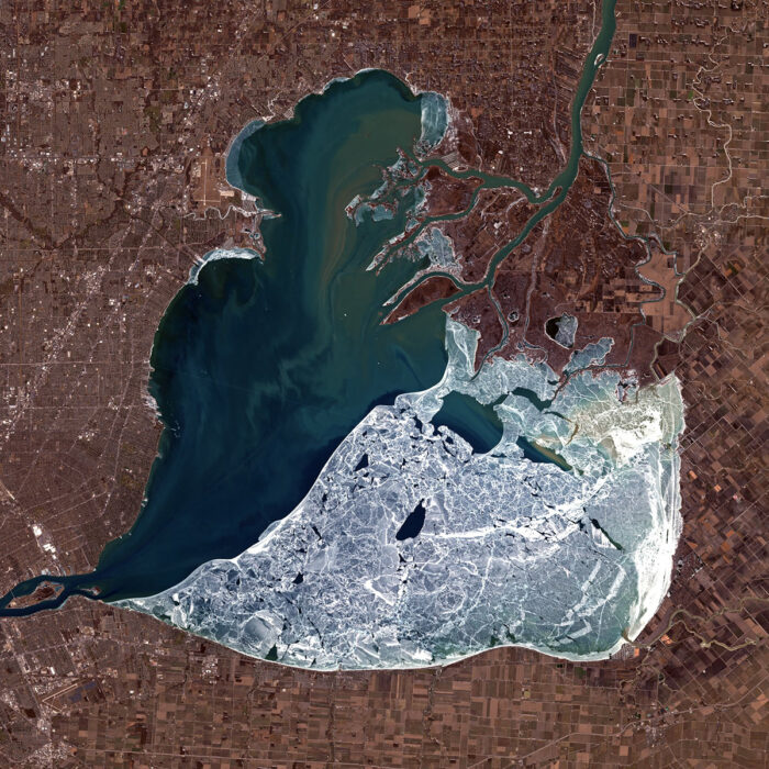 Satellite image of a half frozen lake in the shape of a heart.