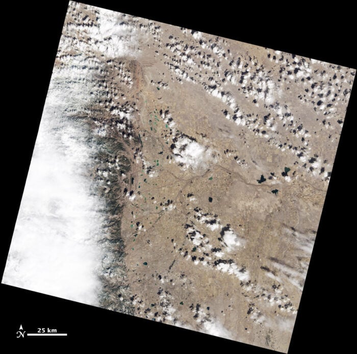 Natural color Landsat scene showing a brown landscape covered by small clouds that dot the landscape.