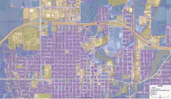 A faded aerials with purple lines for parcels and yellow transparent polygons for selected parcels.