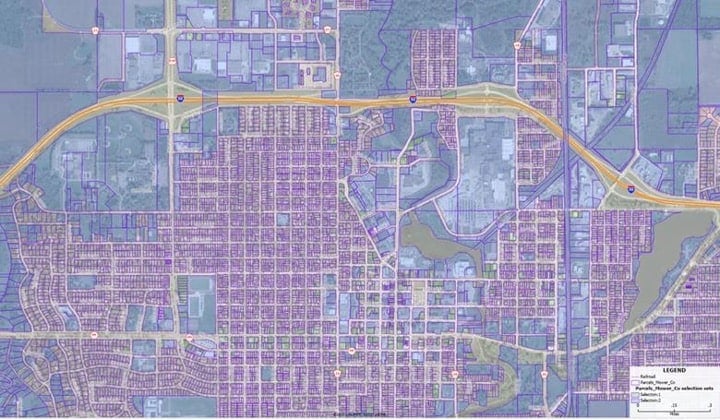 A faded aerial with purple lines for parcels and yellow points showing selected parcels.