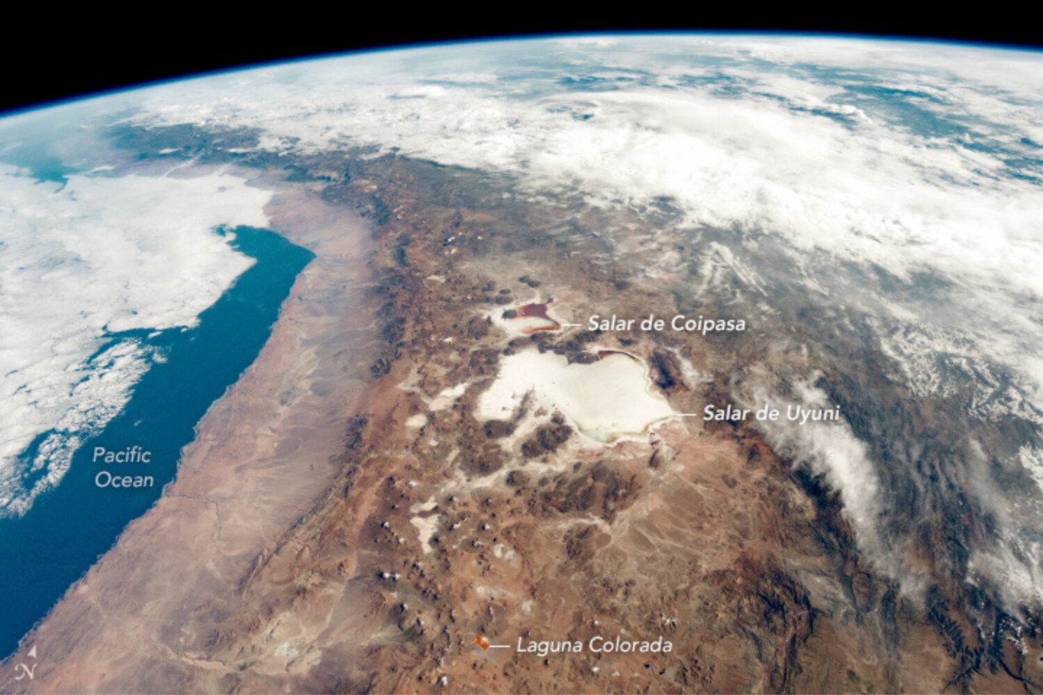 An oblique view of a large salt flat and mountains from space.