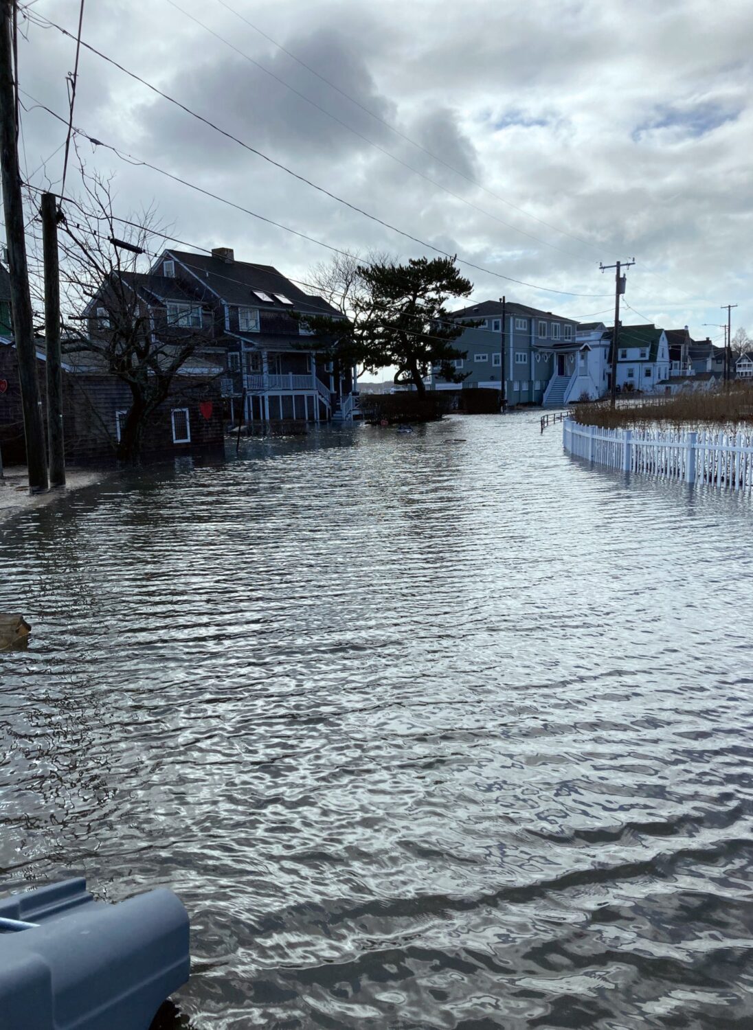 A flooded street with buildings in the background.