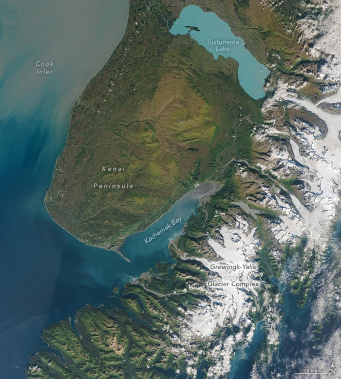 A satellite image of a peninsula with a turquoise lake.